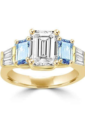 Classic Wide Ring with a 2 Ct. Emerald Cut Brilliant Masterpiece in the center, saluted on each side by a 0.5 ct. Emerald Cut Aquamarine Stone and clear white Baguette Masterpieces further down. 3.5 Cts. T.W, in 14K Solid Gold.