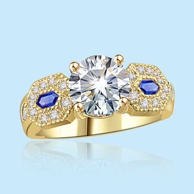 Impressive ring, its 2.0 ct. round cut Diamond Essence diamond set off by lozenge-shaped Sapphire Essence stones embedded with melee. 2.30 cts. w.t. in 14K Solid Gold.