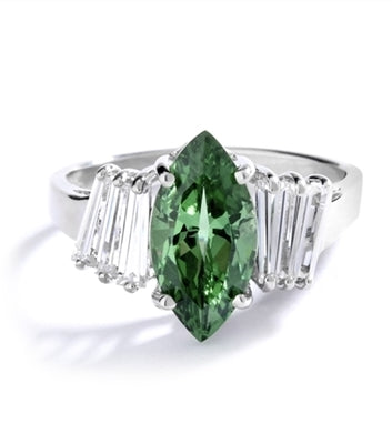 Erin - 1.5 Cts. Marquise Cut Emerald Essence is shining bright in center, accompanied by 3 Baguettes on each side. In Platinum Plated Sterling Silver.