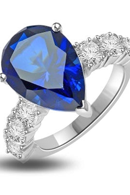 Diamond Essence Designer Ring with 5.50 cts. Pear Cut Sapphire Essence in center and three round stones on each side of center. 7.0 Cts. T. W. In Platinum Plated Sterling Silver.