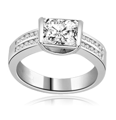 A unique East-West design, with a Channel Set 1.5 Ct. Radiant Emerald Cut Diamond Essence Center and a bevy of Melee accents down the band for an exhilarting sensation, in Platinum Plated Sterling Silver.