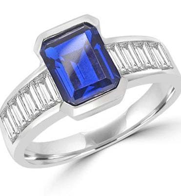Escape with this Wide Band Ring with Channel Set Emerald cut Sapphire Essence, 2.5 cts., separated by straight Diamond Bright Baguettes set vertically for a totally magnificent effect. 3.5 cts. T.W. set in Platinum Plated Sterling Silver.