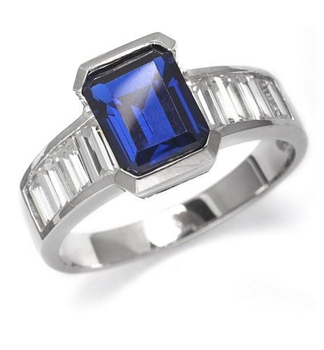 Escape with this Wide Band Ring with Channel Set Emerald cut Sapphire Essence, 2.5 cts., separated by straight Diamond Bright Baguettes set vertically for a totally magnificent effect. 3.5 cts. T.W. set in Platinum Plated Sterling Silver.