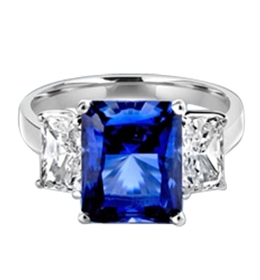Sapphire Ring - 4.0 Cts. Radiant Emerald cut Saphhire Essence in center accompanied by Radiant Emerald cut Diamond Essence on sides. 5.0 Cts. T.W. set in Platinum Plated Sterling Silver.
