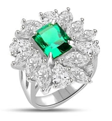 Diamond Essence classic cocktail ring. 2.5 Ct. Radient Emerald cut Emerald Essence surrounded by marquise cut and pear cut Diamond Essence in floral setting. 11.0 cts.T.W. set in Platinum Plated Sterling Silver.