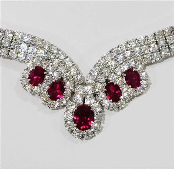Magnificent Ruby Necklace. 3.0 Cts. Oval cut Ruby Essence in the center and 1.50 Cts. each Ruby Essence encircled by Diamond Essence stones. making 3 rows all around neckline. Special lock- on clasp to secure it. Just perfect to make any day a special day