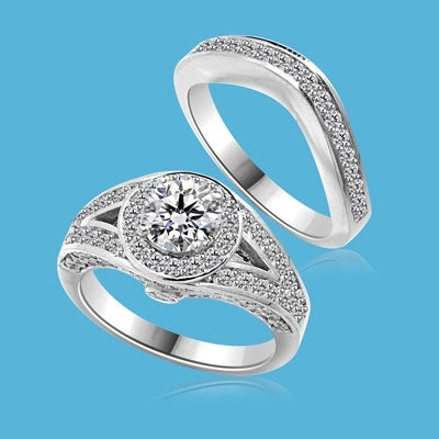 Wedding Set - 1.0 Ct. Round Brilliant Diamond Essence in center with Melee set in intervening design on either side and Wedding band with delicately set Melee. 2.35 Cts. T.W. in 14K White Gold.